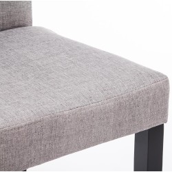 Juego de 4 sillas de comedor Ina, tapizadas en tela negra y gris claro.